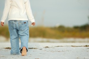 Child walking barefoot on beach