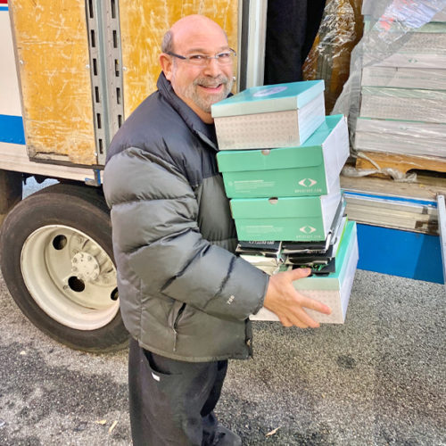 Dr. Brook holding shoe boxes